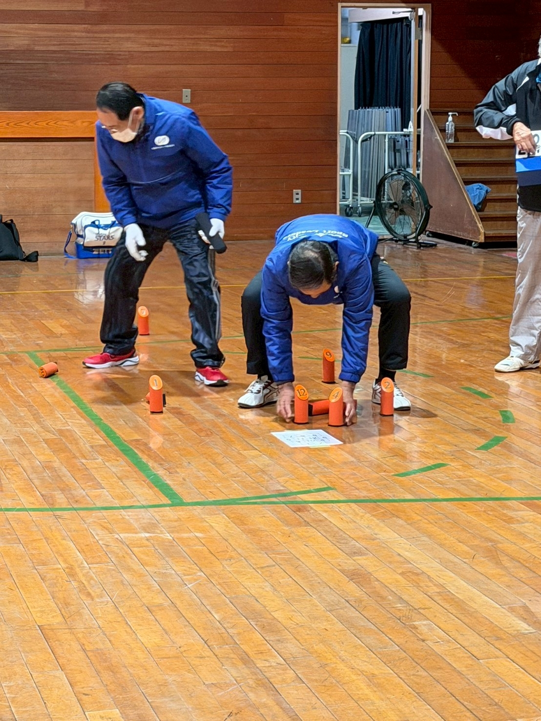 選手が倒れたモルックを立てます